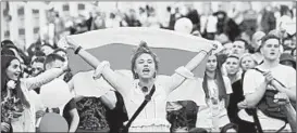  ?? SERGEI GAPON/GETTY-AFP ?? A woman holds a Belarusian flag as she joins a protest rally Friday in Minsk, Belarus.