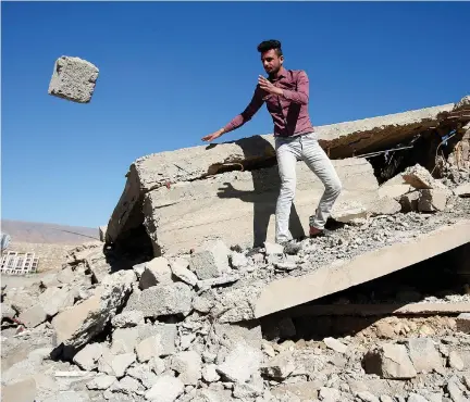  ?? (Khalid al-Mousily/Reuters) ?? A YAZIDI man pulls rubble from his house in Sinjar that ISIS terrorists destroyed in February.