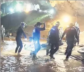  ?? THAI NAVY SEAL FACEBOOK PAGE VIA AP ?? Rescuers hold an evacuated boy inside the Tham Luang Nang Non cave. The daring rescue mission in the treacherou­s confines of a flooded cave has already caught Hollywood’s eye.