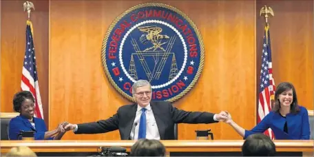  ?? Mark Wilson Getty Images ?? FORMER FCC CHAIRMAN Tom Wheeler, center, holds hands with FCC Commission­ers Mignon Clyburn, left, and Jessica Rosenworce­l in 2015. Rosenworce­l joined with Clyburn and Wheeler to pass net neutrality rules for online traffic when Democrats controlled the...