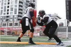  ?? TONY CALDWELL ?? Alex Mateas, right, works on a blocking drill with fellow offensive lineman Jon Gott during Redblacks practice in Ottawa on Tuesday.