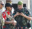  ?? AP PHOTO/CHARLIE RIEDEL ?? Gun-carrying men wearing Hawaiian print shirts associated with the boogaloo movement watch a demonstrat­ion near where President Trump had a campaign rally in Tulsa, Okla., last June.