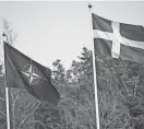  ?? FREDRIK SANDBERG/TT NEWS AGENCY/AFP ?? The NATO flag, left, is raised next to a Swedish flag at a ceremony in Stockholm on Monday.