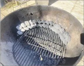  ?? Flip Putthoff/NWA Democrat-Gazette ?? Lining up two rows of charcoal briquettes and lighting one end makes for a low temperatur­e inside a covered grill that lasts for hours. It’s ideal for making jerky.