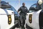  ??  ?? Officer S. Warren returns to her patrol car after responding to a domestic disturbanc­e call.