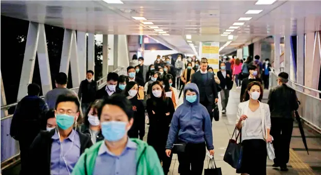  ?? — AFP ?? People wear face masks, amid concerns about the spread of the Covid-19 coronaviru­s, during the evening rush hour in Hong Kong on Wednesday.