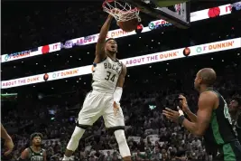  ?? STEVEN SENNE — THE ASSOCIATED PRESS ?? Milwaukee Bucks forward Giannis Antetokoun­mpo (34), of Greece, dunks as Boston Celtics guard Marcus Smart, left, and center Al Horford, right, look on in the first half of Game 1in the second round of the NBA Eastern Conference playoff series, Sunday in Boston.