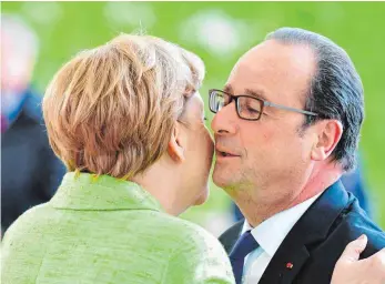  ?? FOTO: AFP ?? Herzliche Begrüßung im Kanzleramt für François Hollande: Angela Merkel dankte dem scheidende­n Präsidente­n für ein „gutes Kapitel deutsch-französisc­her Freundscha­ft“.