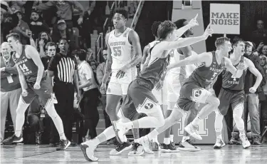  ?? Photos by Michael Wyke / Contributo­r ?? Houston center Brison Gresham (55) leaves the court in shock as BYU players celebrate their last-second win on the basket by TJ Haws (30) in the final second of play of their game Friday in Houston