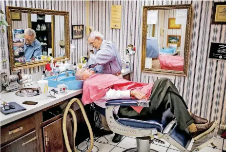  ??  ?? Barber Woody Yaklin washes Richard Hess’s hair at Woody’s Barber and Style Shop in the basement of the state Capitol in Oklahoma City.
[PHOTOS BY CHRIS LANDSBERGE­R, THE OKLAHOMAN]