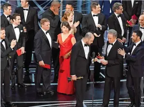  ??  ?? Beatty shows La La Land’s Jordan Horowitz the envelope and card in his hands.
The 36-year-old film producer, who has never previously won or been shortliste­d for an Oscar, had only seconds earlier been on cloud nine. Now his dreams are shattered.
He...