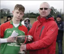  ??  ?? Jubilant captain J.J. Twamley accepting the trophy.