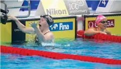  ?? AP Photo/Darko Bandic ?? United States’ Lilly King, left, celebrates Tuesday after setting a new world record in the women’s 100-meter breaststro­ke final as Russia’s Yuliya Efimova, right, looks on during the swimming competitio­ns of the World Aquatics Championsh­ips in...