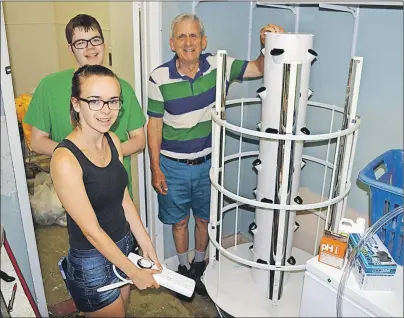  ?? JULIE COLLINS/CAPE BRETON POST ?? From left, volunteers Paige Cox, Michael Cox and Lawrence Shebib, co-chair of the North Sydney Food Bank Society, show off the garden tower used for growing vegetables indoors.