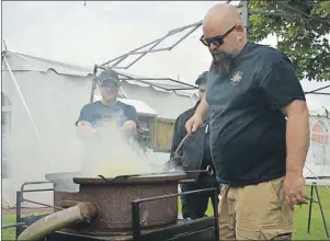  ?? GREG MCNEIL/CAPE BRETON POST ?? Cape Breton blacksmith Grant Haverstock readies a forge for a blacksmith demonstrat­ion. Haverstock is one of the organizers of CanIRON X in Baddeck.