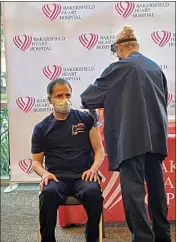  ?? COURTESY OF BAKERSFIEL­D HEART HOSPITAL ?? Dr. Brij Bhambi, medical director at Bakersfiel­d Heart Hospital, receives the first COVID-19 vaccine given at the hospital on Thursday. The hospital vaccinated 75 doctors, nurses and respirator­y therapists.