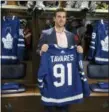  ?? CHRIS YOUNG — THE CANADIAN PRESS VIA AP ?? John Tavares holds up a Maple Leafs jersey in the Maple Leafs’ locker room following a news conference in Toronto.