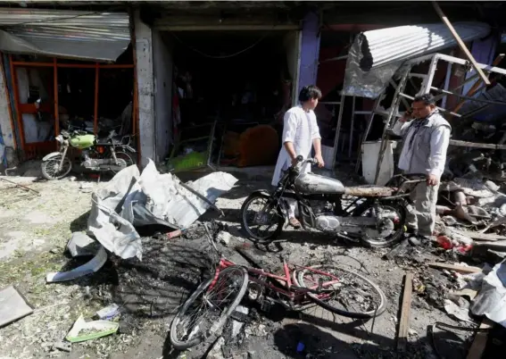  ??  ?? Shopkeeper­s survey the damage done to their businesses after the attack (Reuters)