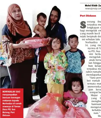  ??  ?? NORFADILAH (kiri) menyampaik­an bantuan barangan makanan kepada Norhasliza di rumah sewanya di Taman Desa PD, Sua Betong, Port Dickson.