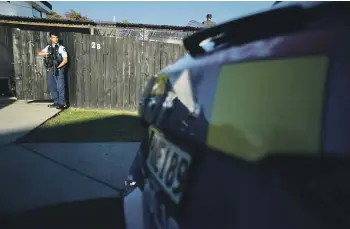  ?? CHRIS MCKEEN/STUFF ?? Police stand guard after three people allegedly kidnapped a woman from a Beach Haven property.