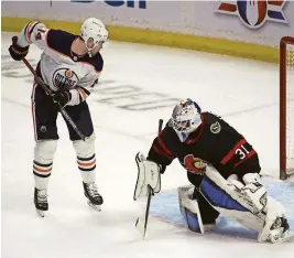  ?? MARC DESROSIERS/USA TODAY SPORTS ?? Oilers center Devin Shore (14) deflects a puck past Senators goalie Anton Forsberg (31) on Thursday.