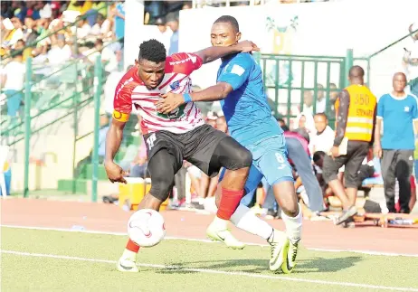  ??  ?? Lobi Stars captain, Solomon Kwambe (L) shields the ball from Enyimba FC striker Abdulrahma­n Bashir during their match in the 2019 Nigeria Profession­al Football League season.