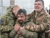  ?? EVGENIY MALOLETKA/AP ?? Ukrainian servicemen cry near the coffin of a comrade during his funeral Friday in Independen­ce Square in Kyiv, Ukraine.