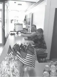  ?? Staff photo by Karl Richter ?? ■ Candy, candles and American flags are for sale as Jennifer Keathley, left, and Saffire Keathley mind the cash register Monday at Keathley’s General Store in downtown Texarkana, Ark. The family business opened Monday after preparatio­ns that took almost a year.