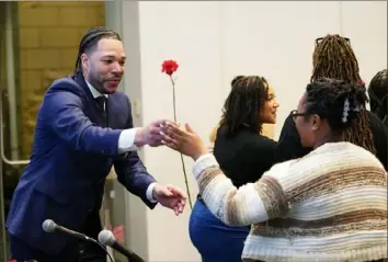  ?? Sebastian Foltz/Post-Gazette ?? Saxon Nelson with Research for Action hands a flower to Hailee Bryant-Roye and other current and former educators Tuesday during the Wisdom to Action diversity in teaching workshop at the August Wilson African American Cultural Center in Downtown.