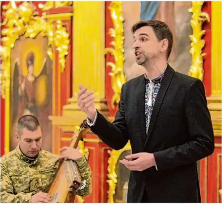  ?? Foto: Maryana Rogovska ?? Der ukrainisch­e Counterten­or Roman Melish bei einem Auftritt in der goldenen St.-andreas-kirche in Kiew. Die Bandura, das ukrainisch­e Nationalin­strument, spielt ein Frontsolda­t.