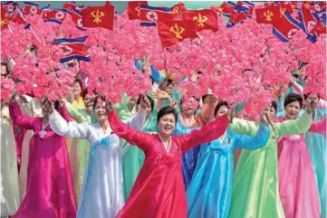  ?? — AFP ?? Women wearing traditiona­l Korean dress wave flowers during a mass rally in Pyongyang. US President Donald Trump on Wednesday confirmed that a senior North Korean official is en route to New York as part of preparatio­ns for a planned summit with leader...