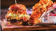  ?? CAESARS ENTERTAINM­ENT ?? Burgers at Guy Fieri’s Vegas Kitchen and Bar include the flavourful Macaroni ’n’ Cheese Cheeseburg­er.