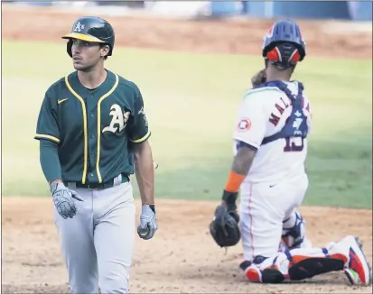  ?? PHOTOS BY MARCIO JOSE SANCHEZ— THE ASSOCIATED PRESS ?? The A’s Matt Olson, left, walks to the dugout after striking out against the Astros during Game 4of the ALDS on Thursday in Los Angeles.