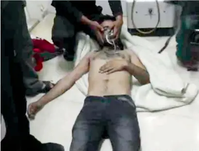  ?? AFP ?? A man lies on the floor with an oxygen mask at a hospital room in Kfar Zeita, some 200 km north of Damascus. —