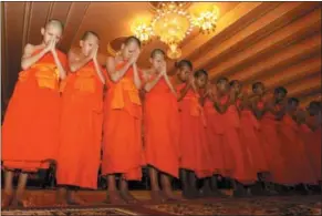  ?? SAKCHAI LALIT — THE ASSOCIATED PRESS ?? Members of Wild Boars soccer team pray during a ceremony marking the completion of their serving as novice Buddhist monks, following their dramatic rescue from a cave in Mae Sai district, Chiang Rai province, northern Thailand.