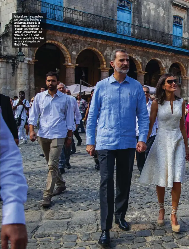  ??  ?? Felipe VI, con la guayabera azul de cuatro bolsillos y dos jaretas, pasea de la mano con Letizia por la Plaza de la Catedral de La Habana, considerad­a una plaza-museo. La Reina lleva un vestido de Carolina Herrera y alpargatas de Mint & Rose.