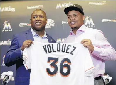  ?? ALAN DIAZ/AP ?? Marlins President of Baseball Operations Michael Hill, left, and right-hander Edinson Volquez hold up the pitcher’s new jersey as they pose during the press conference Thursday. His two-year deal is for $22 million.