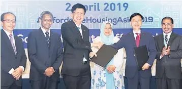  ??  ?? Zuraida (third right) witnessing the MoU exchange between Chung (third left) and Lee. They are flanked by (from left), Cagamas chairman Dato’ Bakarudin Ishak, Bank Negara Malaysia Deputy Governor Abdul Rasheed Ghaffour and Nik Hasyudeen Yusoff of Cagamas Holdings.