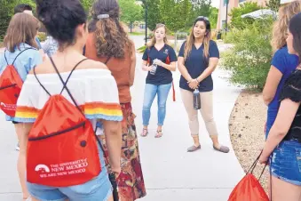  ?? MARLA BROSE/JOURNAL ?? University of New Mexico students Monica Munoz, right, and Kaitlyn Seubert, second from right, lead prospectiv­e students on a tour of campus last week. UNM, like universiti­es around the country, has experience­d falling enrollment after big recession...