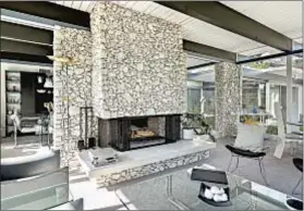  ??  ?? A DRAMATIC FIREPLACE and stone accents are in keeping with the theme of indoor- outdoor living in 3,015 square feet.
