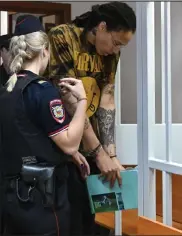  ?? Natalia Kolesnikov­a / AFP via Getty Images ?? U.S. WNBA basketball superstar Brittney Griner enters a defendants' cage before a hearing at the Khimki Court in the town of Khimki outside Moscow on July 15, 2022. - Griner, a two-time Olympic gold medallist and WNBA champion, was detained at Moscow airport in February on charges of carrying in her luggage vape cartridges with cannabis oil, which could carry a 10-year prison sentence.