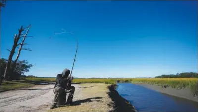  ?? St. Helena Island, S.C. ?? Gullah Geechee fisherman Ricky Wright casts his line Oct. 31 as he fishes for bass in a marsh waterway with eroded banks on
