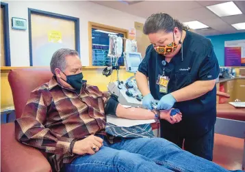  ?? EDDIE MOORE/JOURNAL ?? First Judicial District Judge Francis Mathew donates plasma with the help of Consuelo Chavez-Lucero, assistant donor care supervisor at the United Blood Services blood donation center in Santa Fe. Mathew had COVID-19 and now donates his plasma antibodies to treat people suffering with the virus.