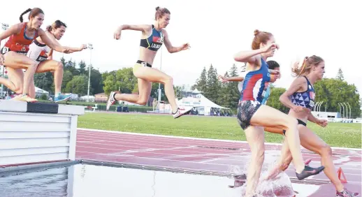  ??  ?? Geneviève Lalonde (au centre) franchit l’obstacle d’eau pendant l’épreuve féminine du 3000 mètres steeple aux Championna­ts canadiens d’athlétisme, jeudi à Ottawa. - La Presse canadienne: Fred Chartrand