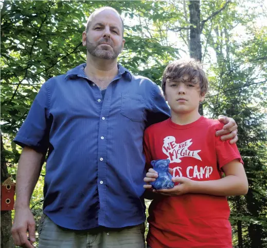  ?? PHOTO MARIE-ÈVE DUMONT ?? Ericson Martin et son fils Roman, 11 ans, se sont rendus à la banque avec cette petite tirelire pour y déposer la monnaie.