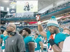  ?? Wilfredo Lee Associated Press ?? MIAMI DOLPHINS defensive end Robert Quinn raises a fist Thursday during the anthem before his team’s preseason game against the Tampa Bay Buccaneers.