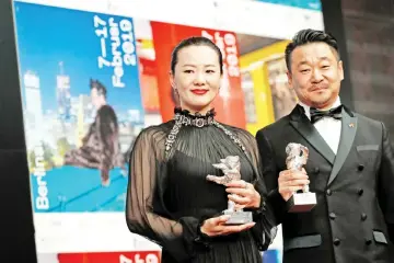  ?? — AFP photo ?? Chinese actor Wang Jingchun and Chinese actress Yong Mei pose with their Silver bears for Best Actors in the film ‘Di Jiu Tian Chang' (So Long, My Son) during a press conference following the awards ceremony of the 69th Berlinale film festival on Saturday in Berlin.