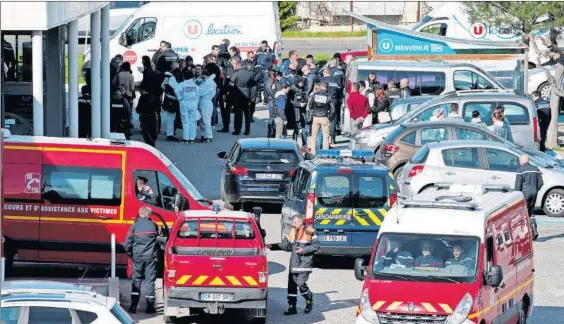  ?? / REGIS DUVIGNAU (REUTERS) ?? Policías y personal de emergencia­s, ante el supermerca­do de Trèbes donde se atrincheró ayer Redouane Lakdim.