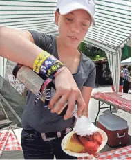  ?? RICK WOOD/MILWAUKEE JOURNAL SENTINEL ?? Hanna Beaber of Fredonia prepares strawberry shortcake for patrons at the strawberry festival.
