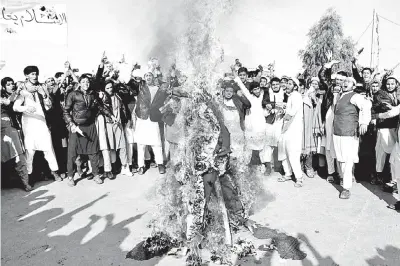  ??  ?? Manifestan­tes afganos queman un muñeco que representa­ba al presidente Donald Trump en Jalalabad.